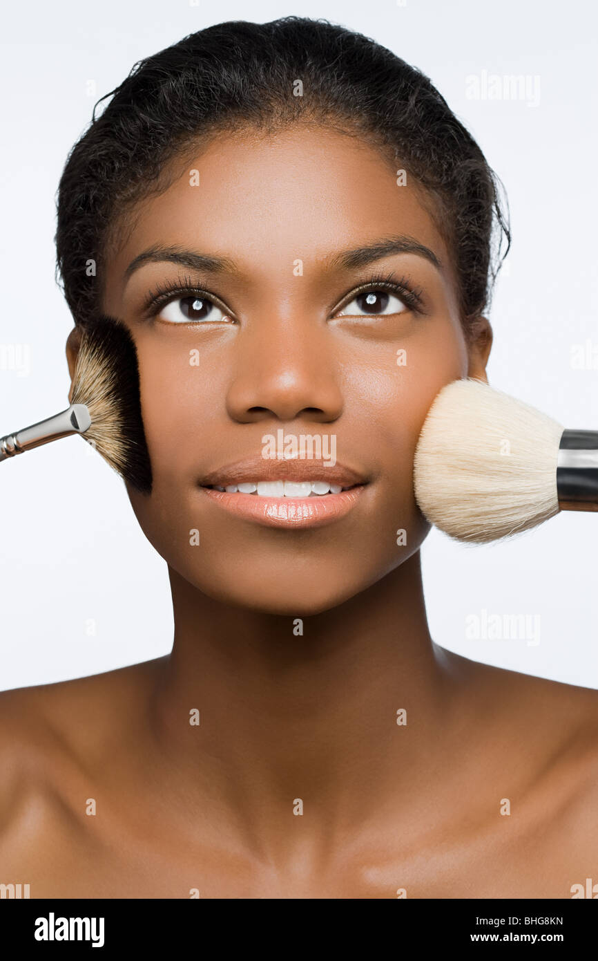Woman with makeup brushes on face Stock Photo