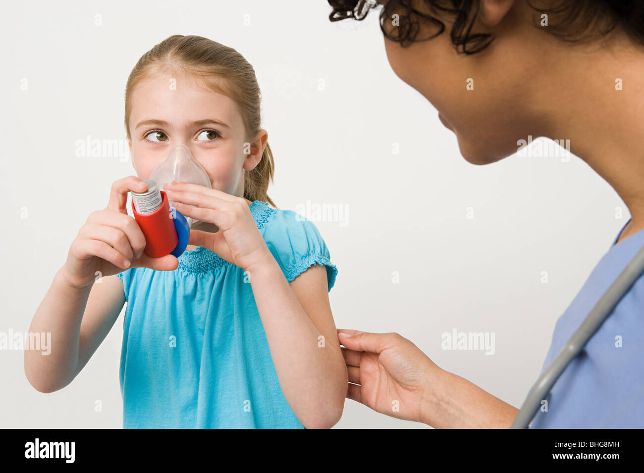 Girl taking asthma inhaler Stock Photo