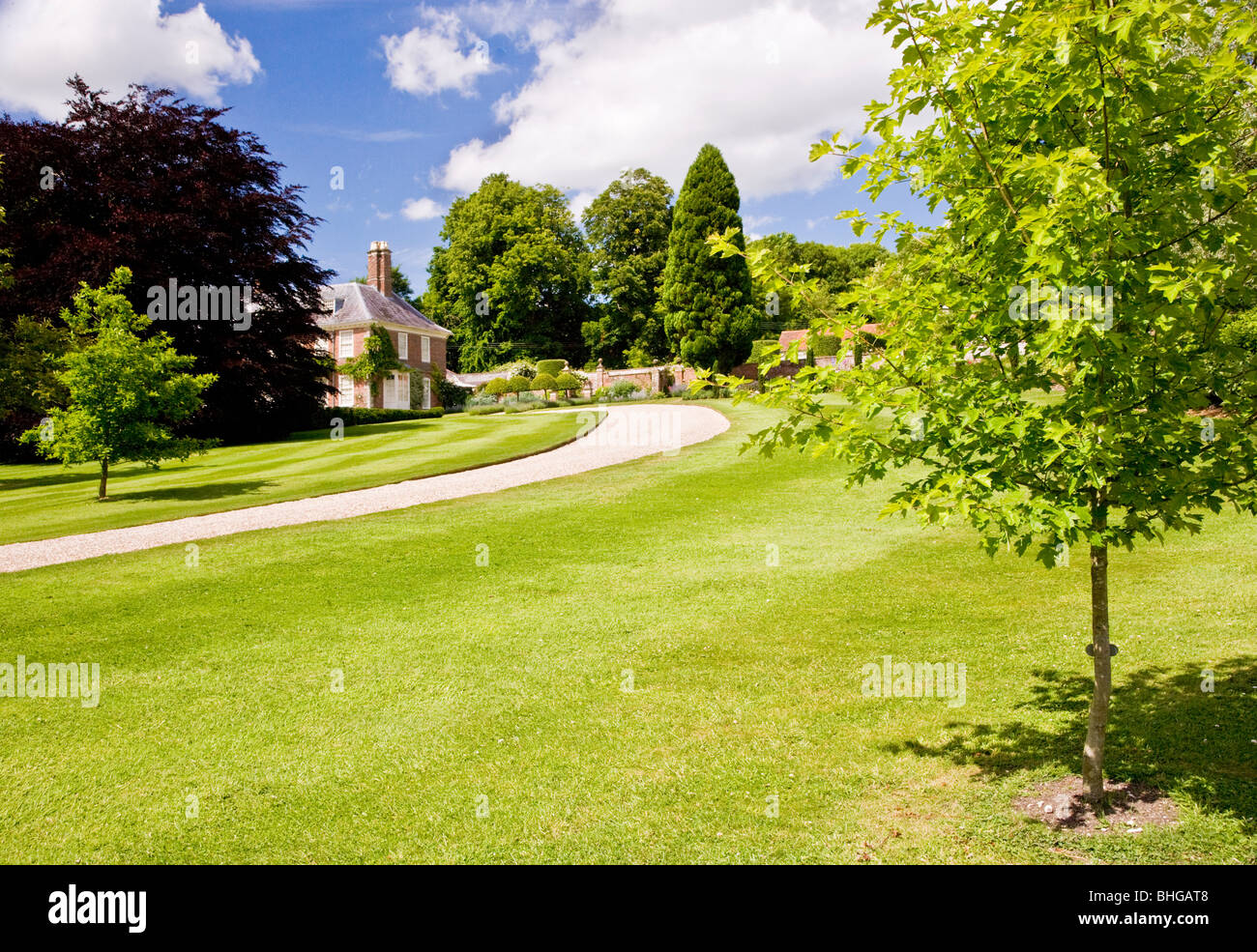 Sweeping drive through parkland up to a typical English country house Stock Photo