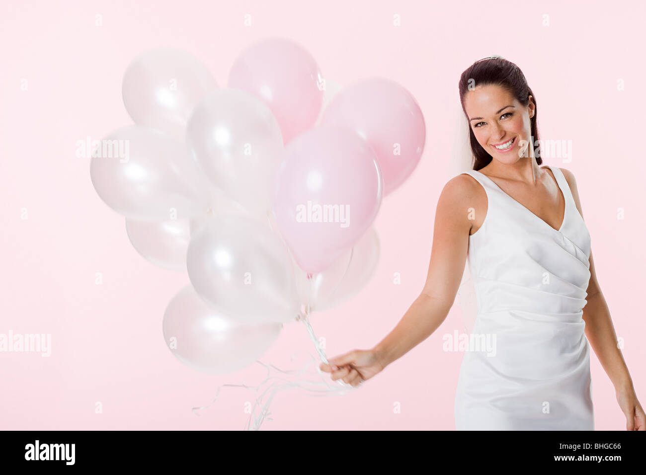 Bride holding a bunch of balloons Stock Photo