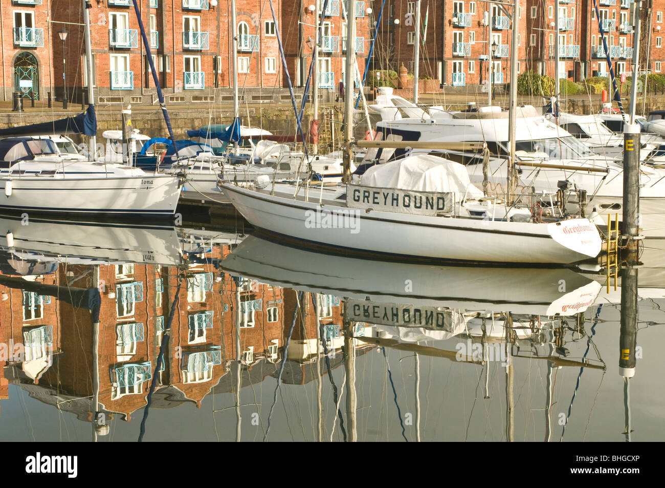 Yachts and apartments reflected in the water of the old dock which is now Swansea Marina Stock Photo