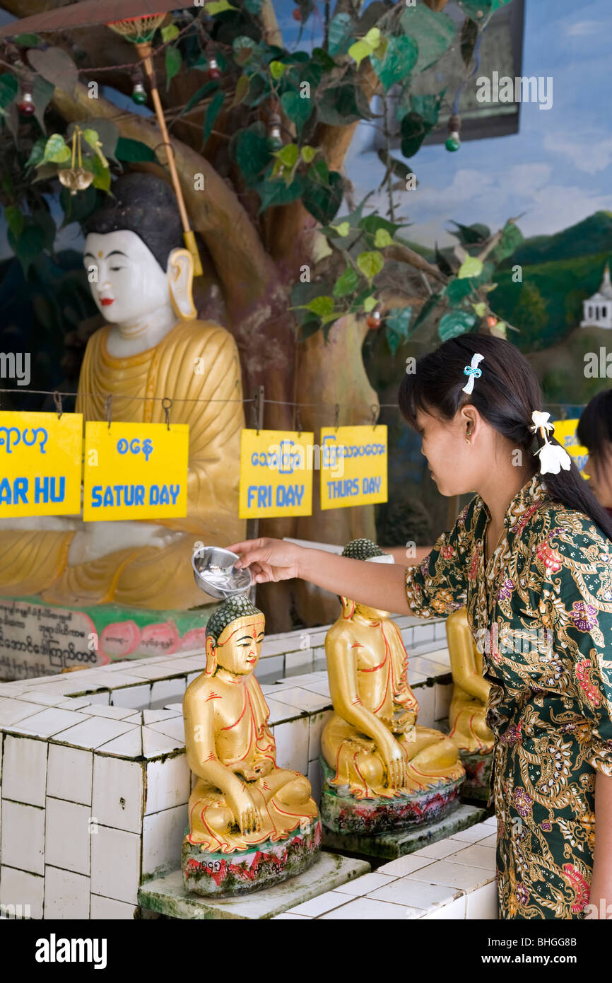 Woman pouring water over a Buddha statue (ritual ceremony). Mahamuni