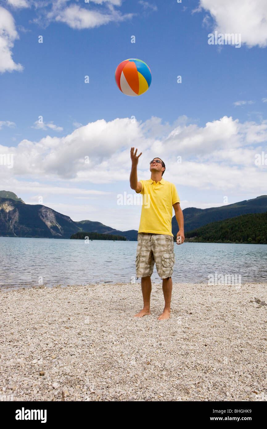 A young man throwing up a beach ball Stock Photo Alamy