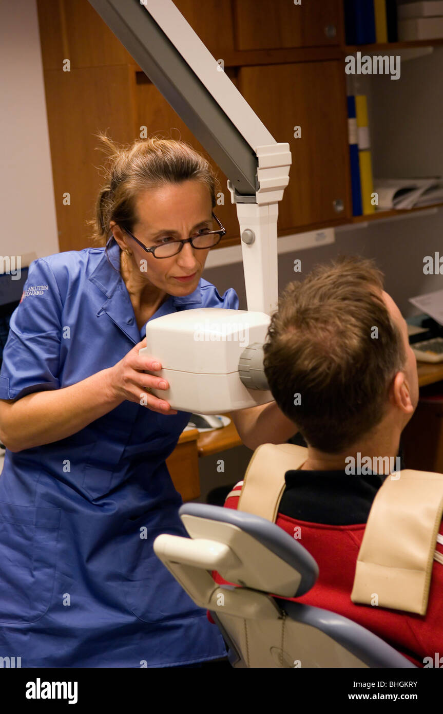 Female dentist positions the Xray against the patients head Stock Photo Alamy