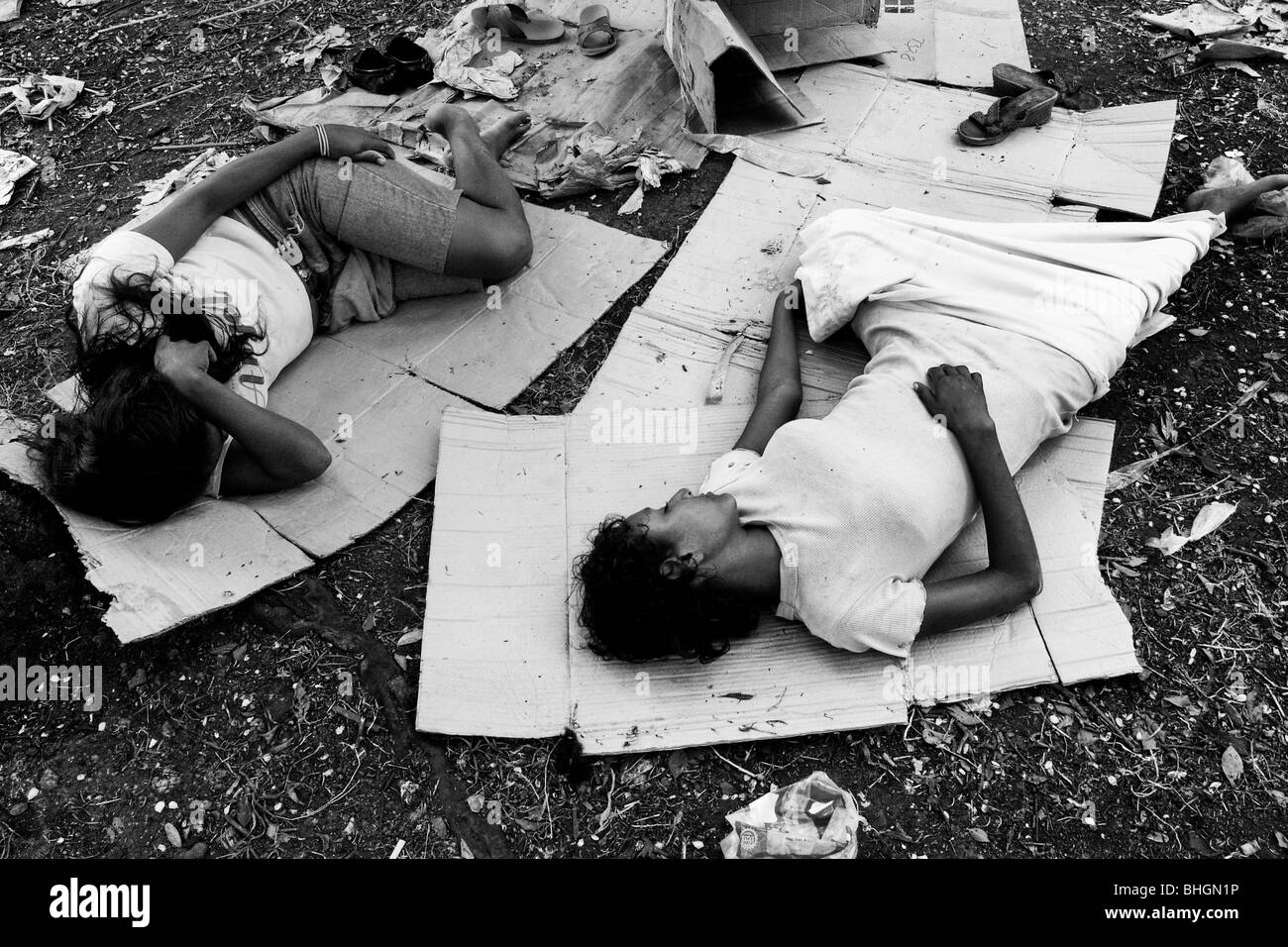 Nicaraguan girls, addicted to the glue sniffing, sleeping on the cardboard in the park, Managua, Nicaragua. Stock Photo