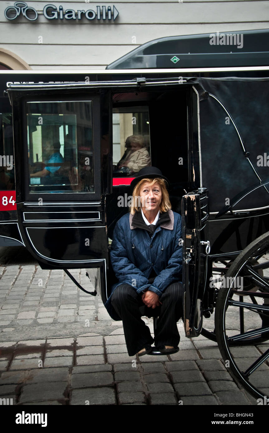 The female driver of a Viennese Fiaker horse carriage waits for the next customers Stock Photo