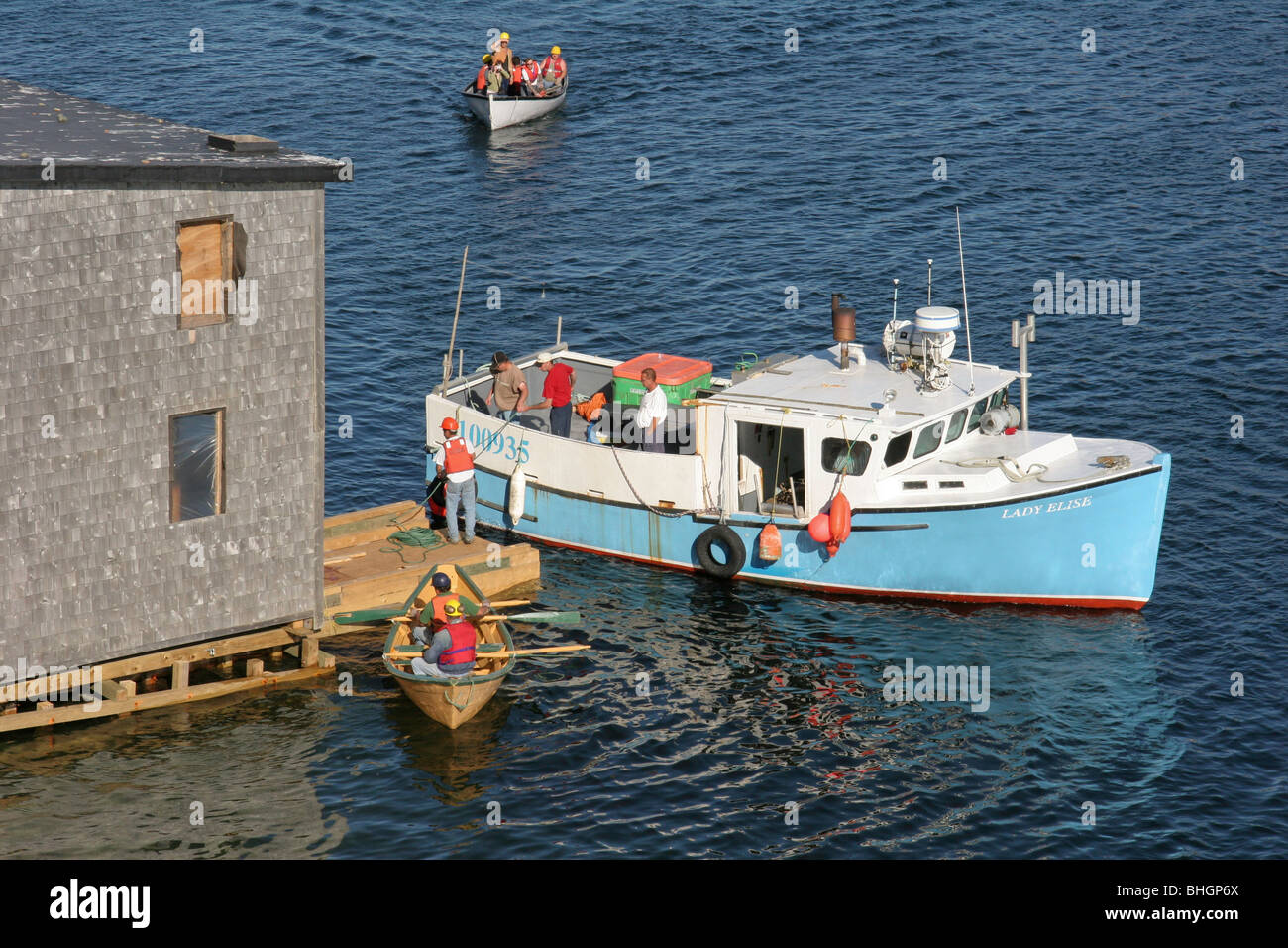 Men of Harbour Breton, Newfoundland prepare to float a building across