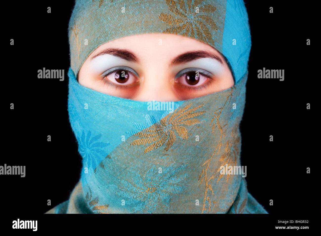 Muslim young woman with blue veil isolated on black Stock Photo