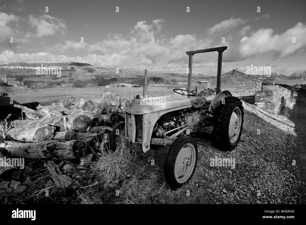 An old tractor sits before fields surrounding Hawes and Gayle in Wensleydale, Yorkshire Dales Stock Photo