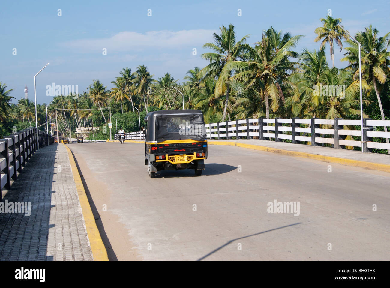 Auto Rickshaw Passing through the Wide Bridge roads in Kerala,India.Beautiful Kerala landscape on Wide Bridge scenery Stock Photo