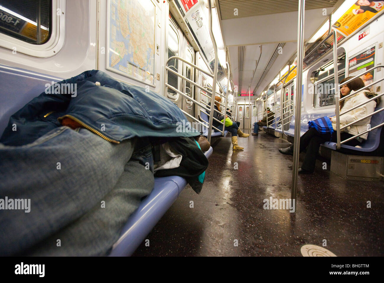 Homeless man sleeping on the subway in New York City Stock Photo