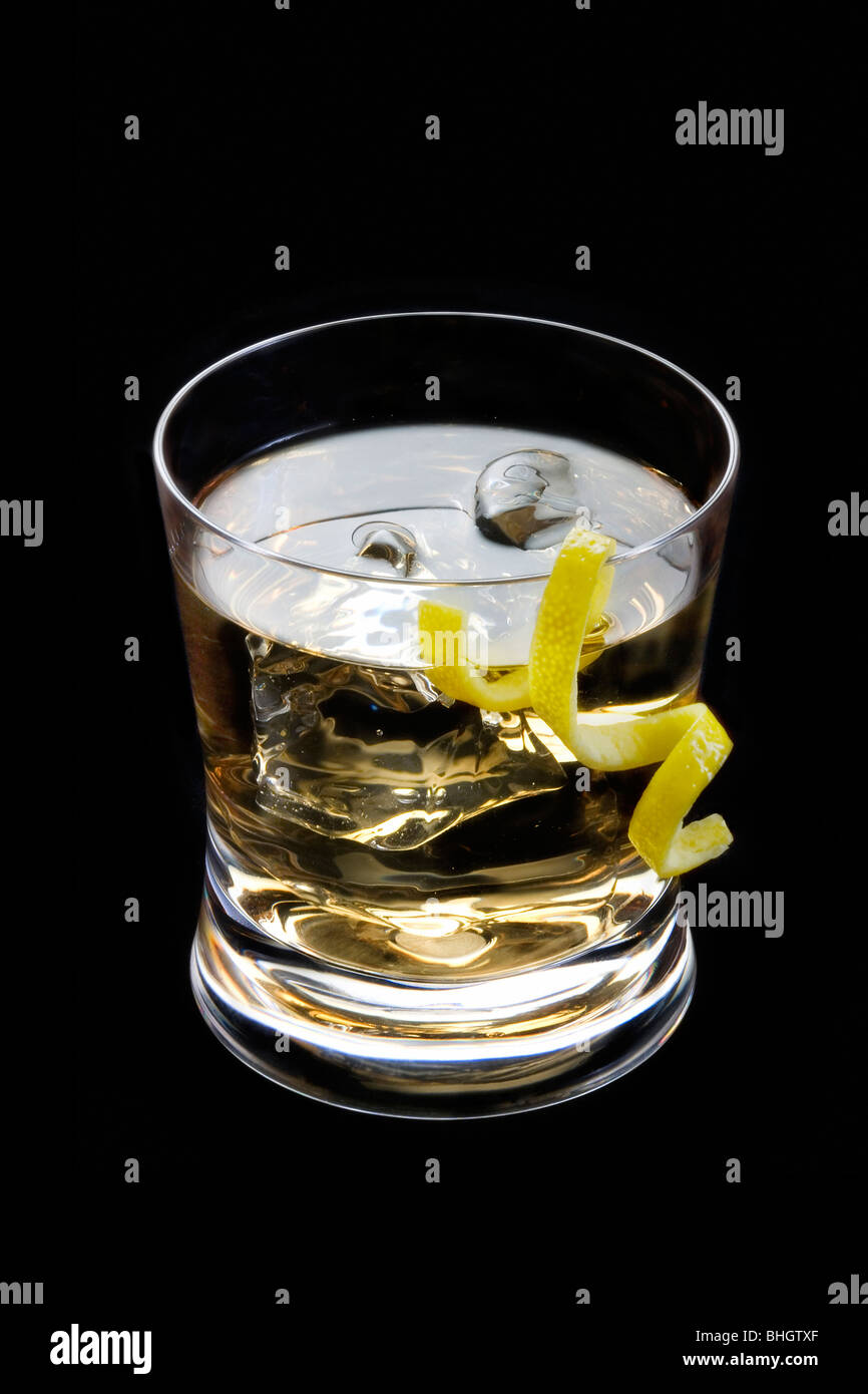 Rusty nail mixed drink with lemon peel on a black background Stock Photo