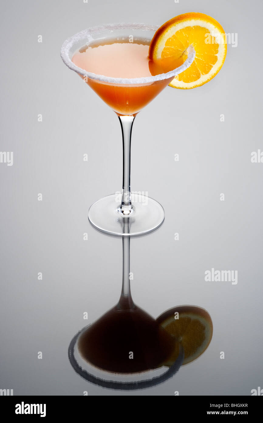 Sidecar mixed drink with orange garnish and sugar rim on plain gray background Stock Photo