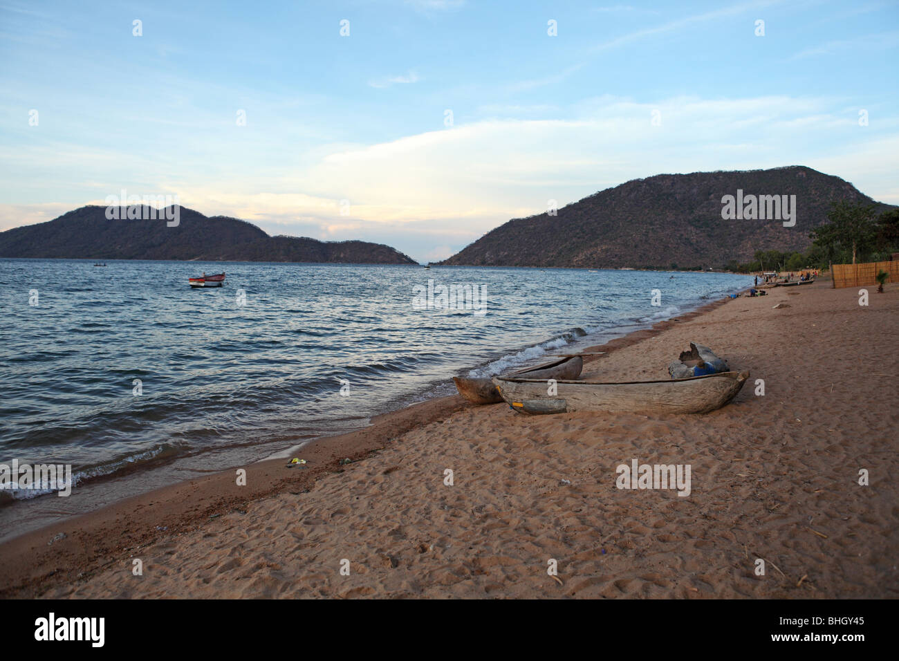 A dugout mekoro canoe sits on the edge of Lake Malawi in the village of Chembe, Cape Maclear, Malawi Stock Photo