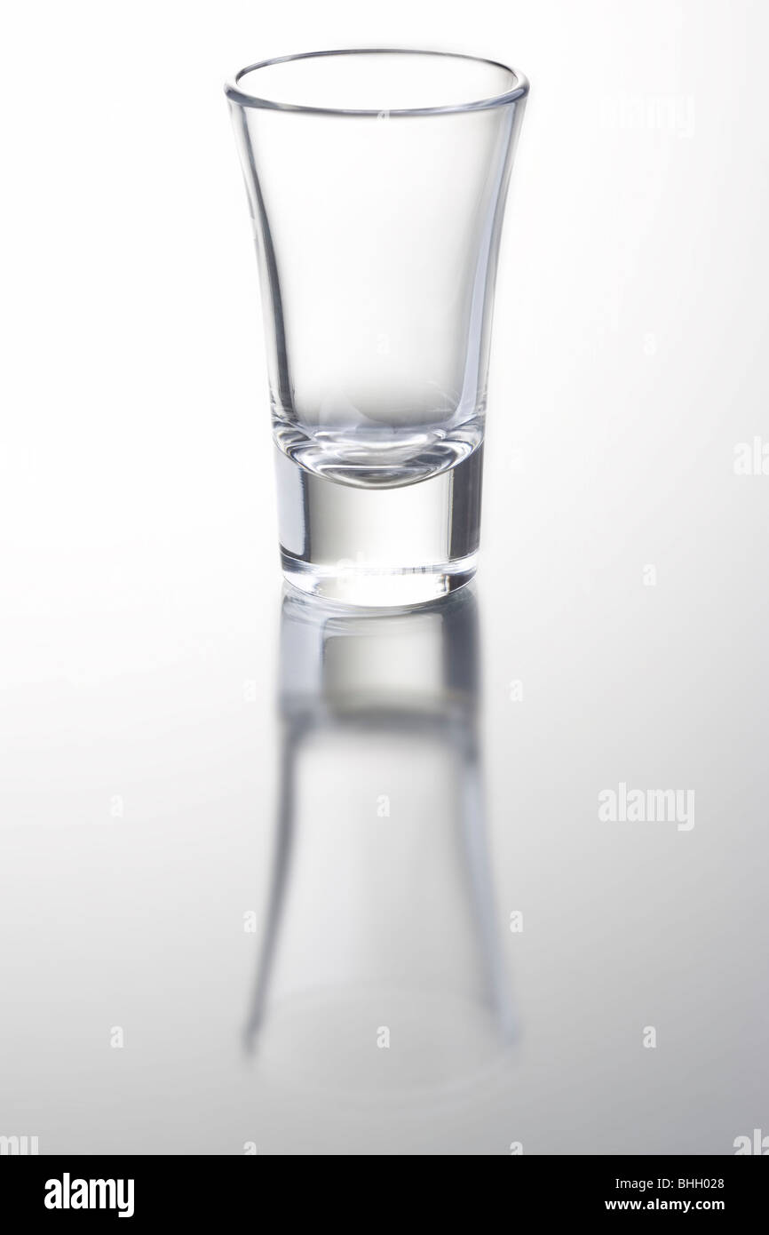 empty shot glass on gray background with reflection Stock Photo - Alamy