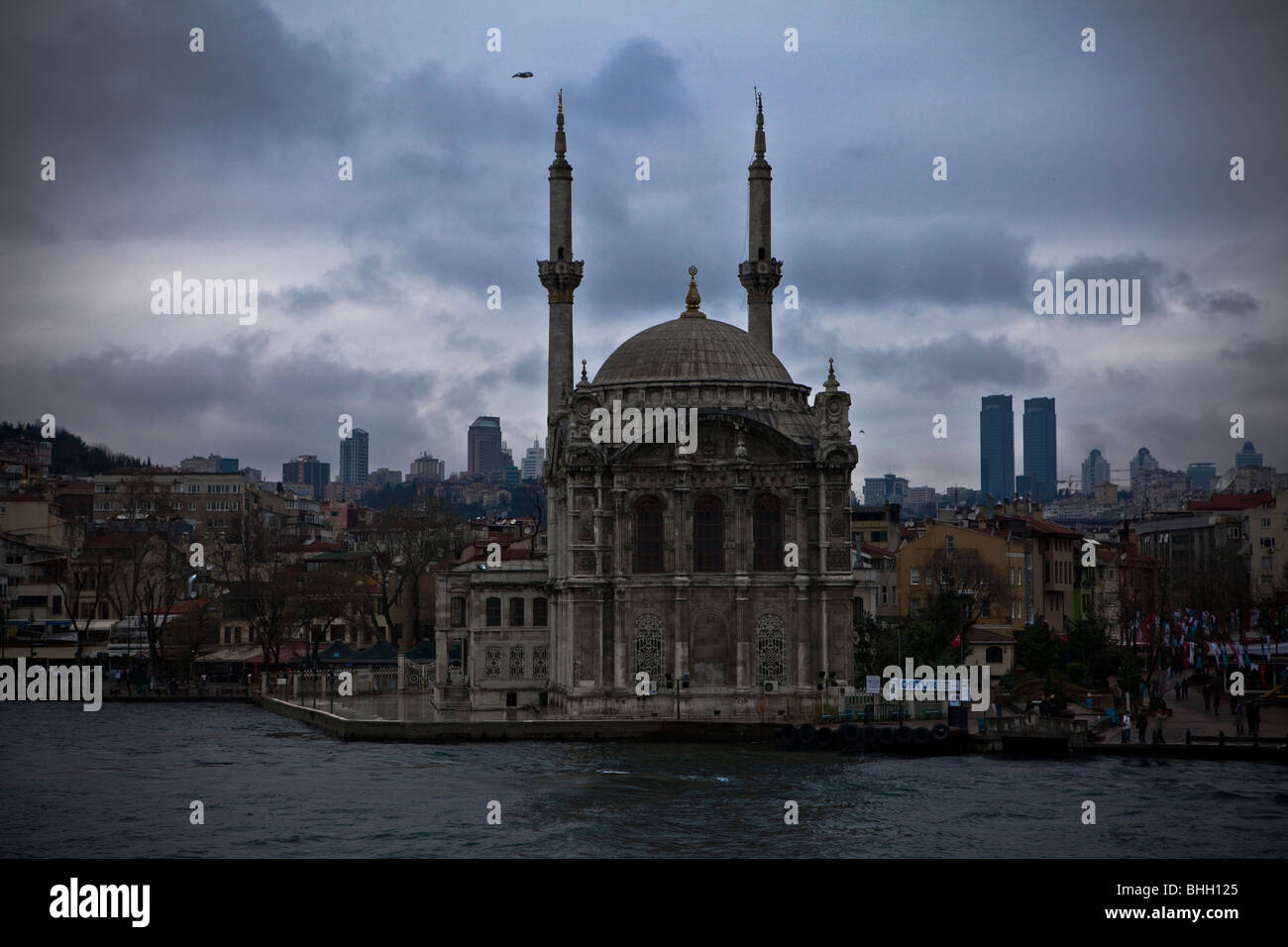 View of the Ortakoy Mecidiye Mosque and business towers from the Bosphorus, commissioned by Sultan Abdulmecit in Istanbul Turkey Stock Photo