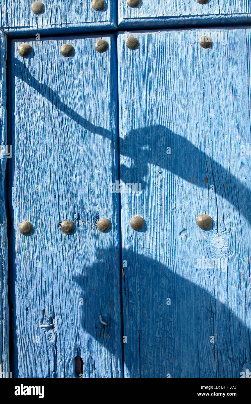 Man's shadow knocking at wooden door. Stock Photo
