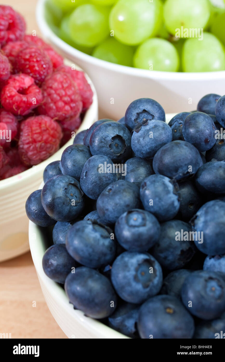 Three bowls of healthy breakfast berries, raspberries, blueberries and grapes Stock Photo