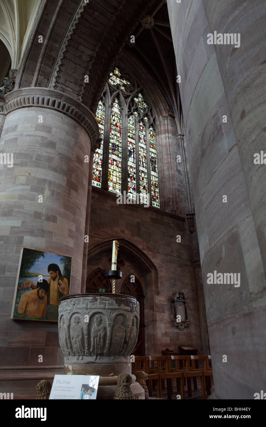 The West window and stone Font at Hereford Cathedral,both framed by the enormous columns framing both subjects. Stock Photo