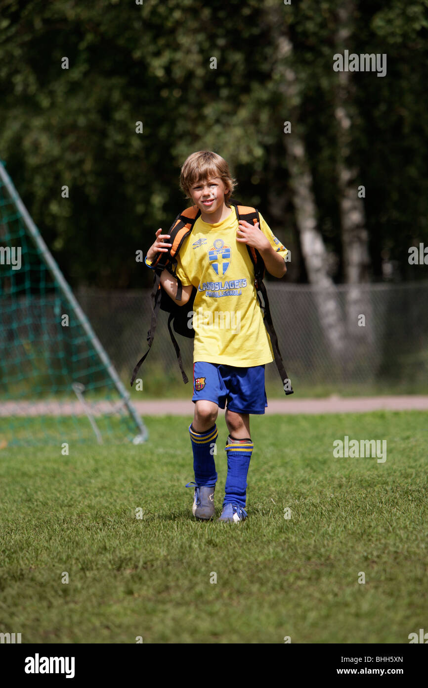 Boy crossing a football field, Sweden. Stock Photo