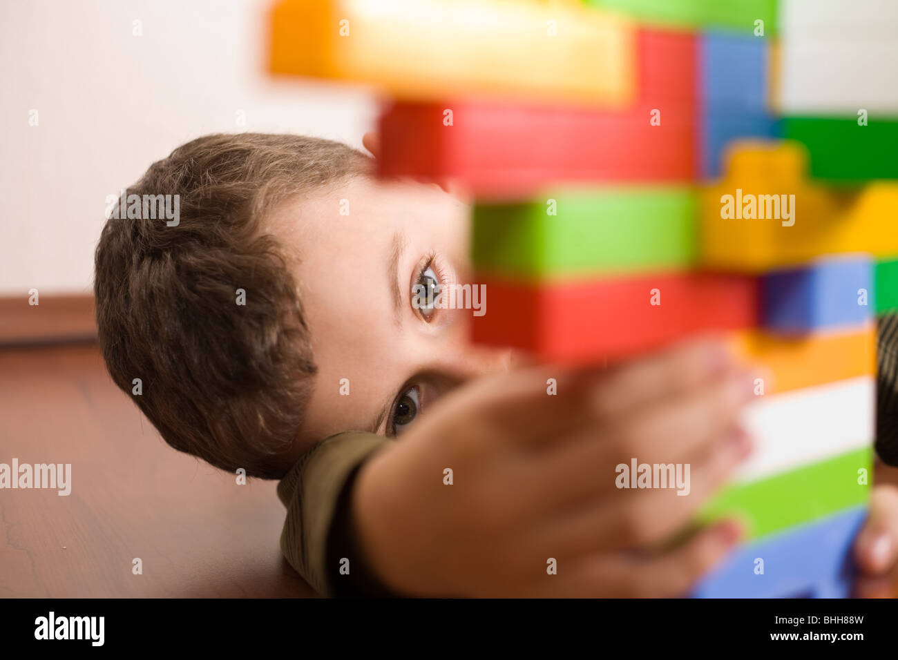 8 year old boy playing with colorful cubes on the floor Stock Photo
