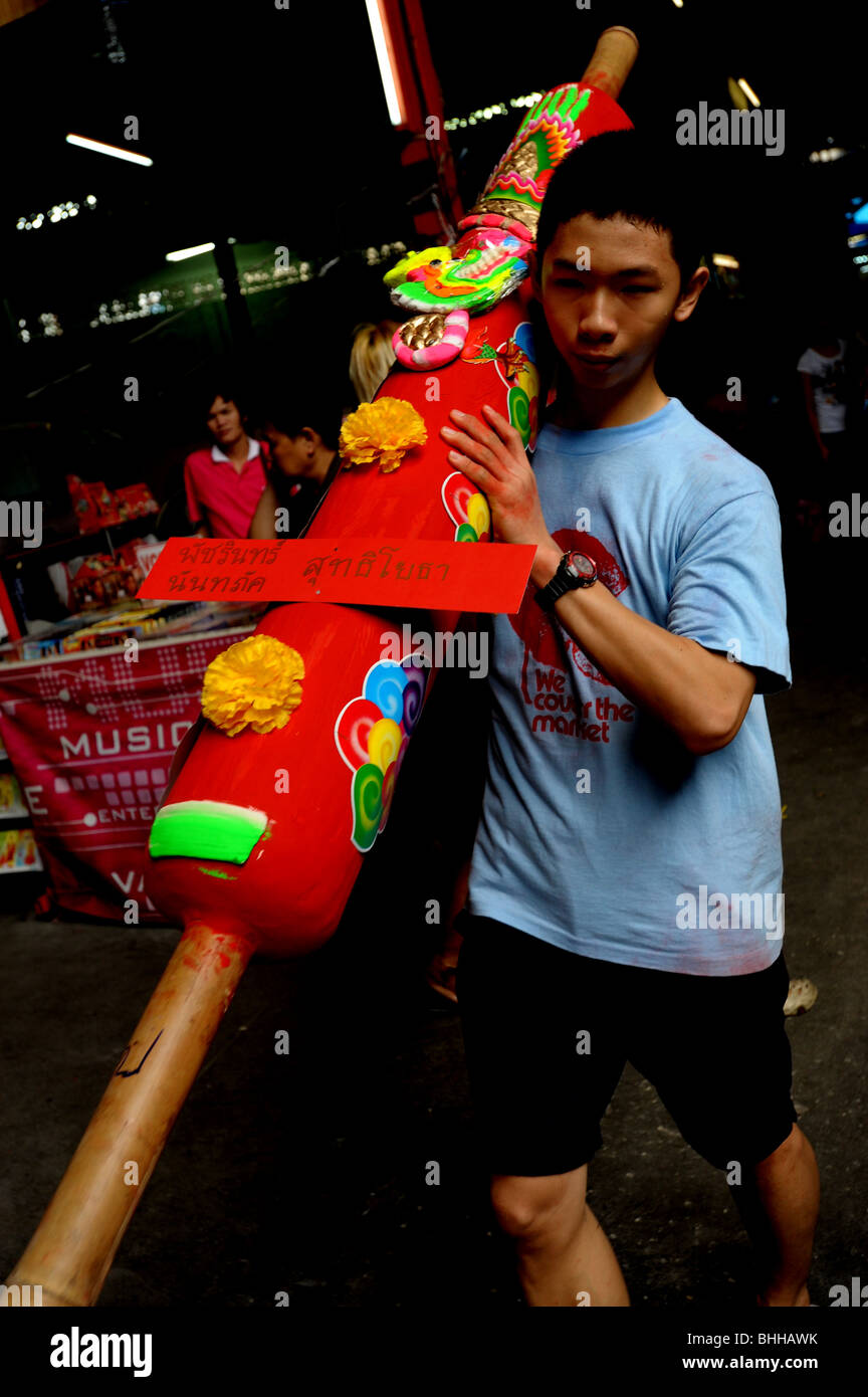 temple boy carrying giant candle , vegetarian festival , bangkok , thailand Stock Photo