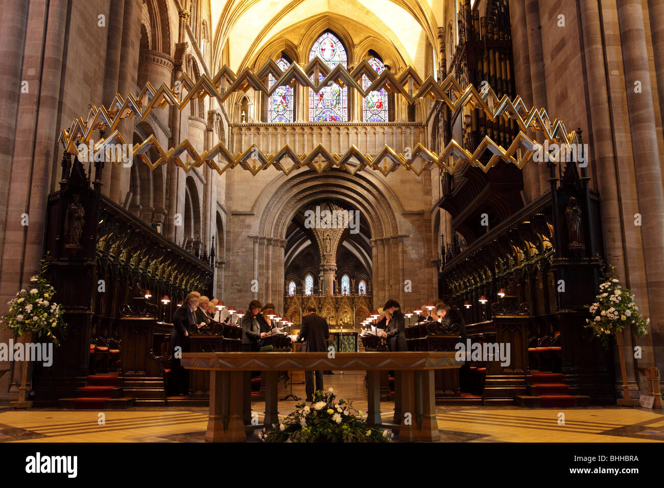 With The Hereford Corona and The Altar Table below,the Choir practice in the background of Hereford Cathedral. Stock Photo