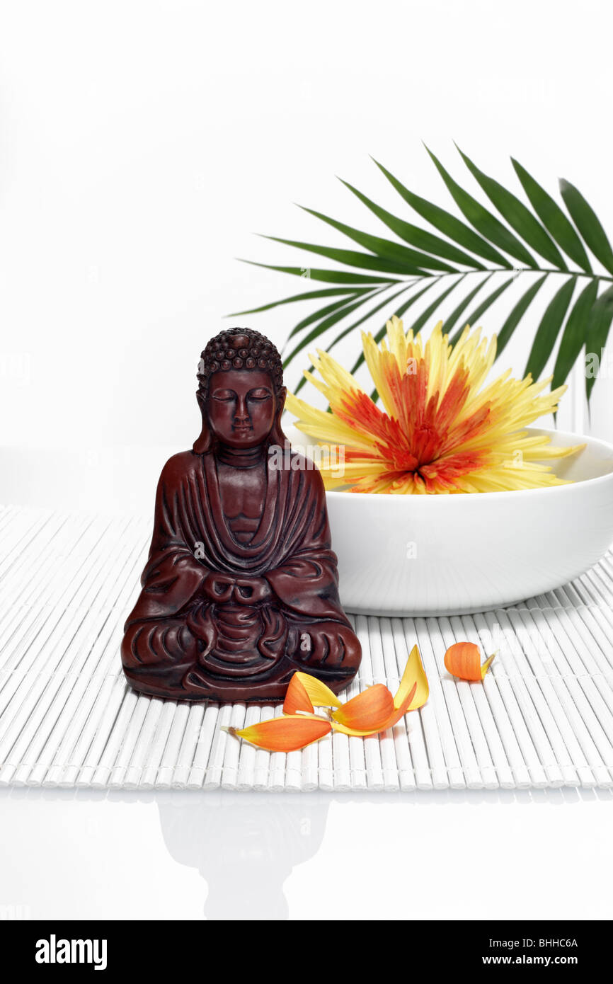 Buddhafigur vor Porzellanschale mit Chrysantheme Stock Photo