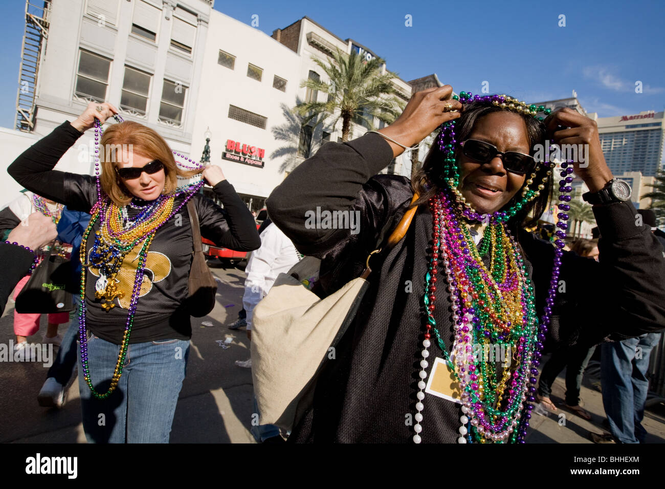 Parade goers wearing beads thrown from Krewe of King Arthur, Mardi Gras
