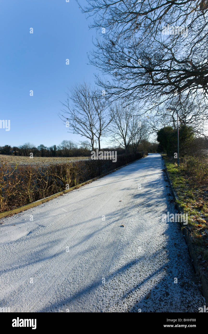 a country road covered with snow and ice in the winter in the ...