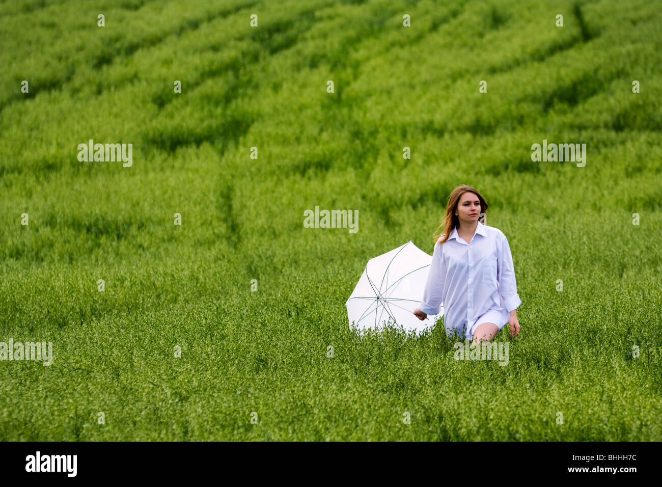 Happy young woman walking in a field Stock Photo - Alamy