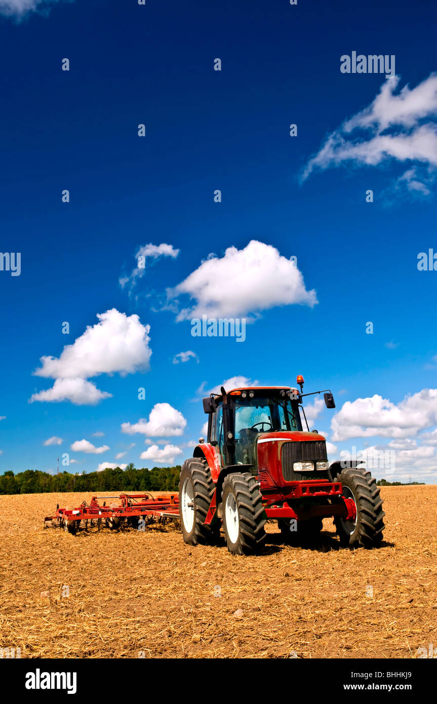 Small scale farming with tractor and plow in field Stock Photo