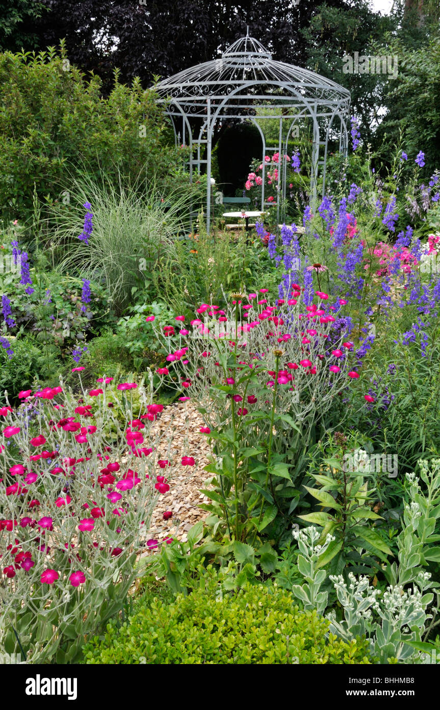 Crown pinks (Lychnis coronaria syn. Silene coronaria) and rocket larkspurs (Consolida ajacis) in front of a garden pavilion. Design: Marianne and Stock Photo