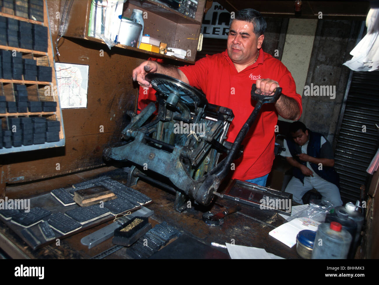 A Mexican man printing a party invitation at a printing workshop, Plaza Santo Domingo, Mexico City. Stock Photo