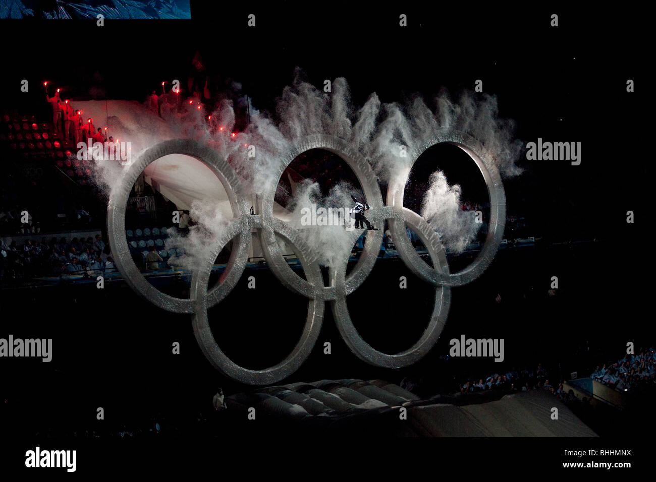 Snowboarder flying through the Olympic rings at the Opening ceremonies of the 2010 Olympic Winter Games Stock Photo