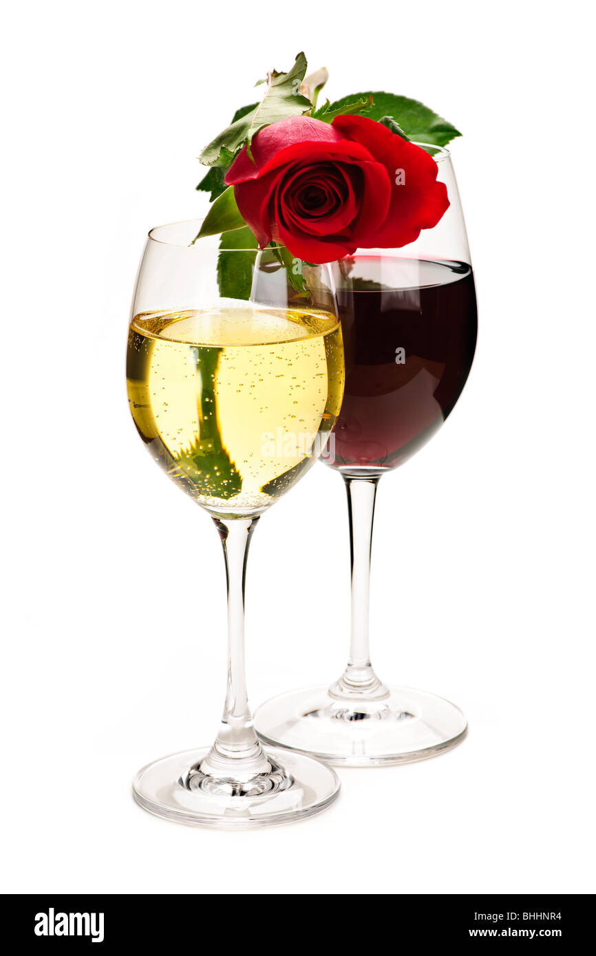 Romantic rose on top of red and white wine glasses isolated on white ...