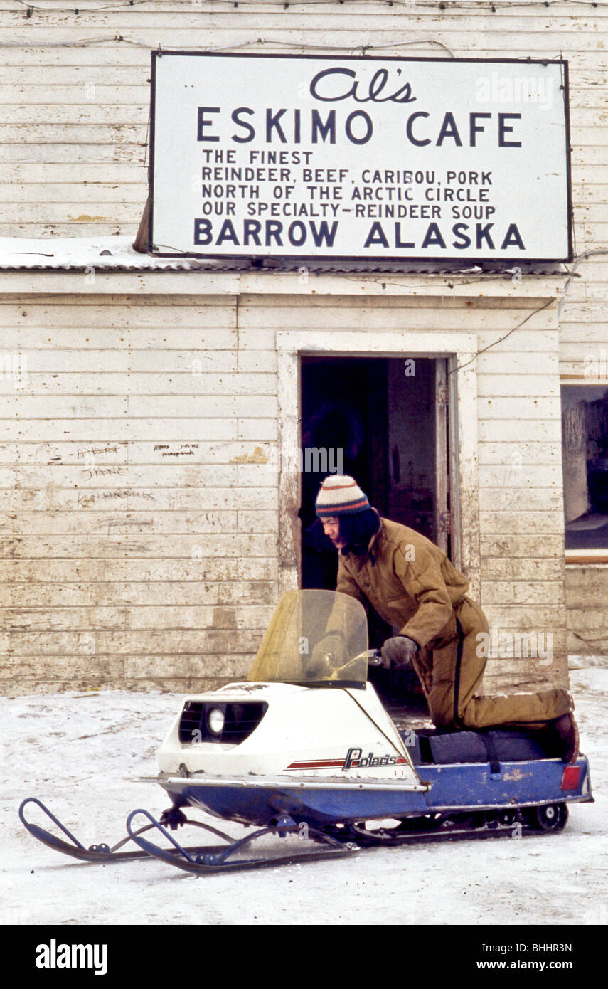 A wellfed Eskimo customer climbs on his snowmobile after lunch at Al's