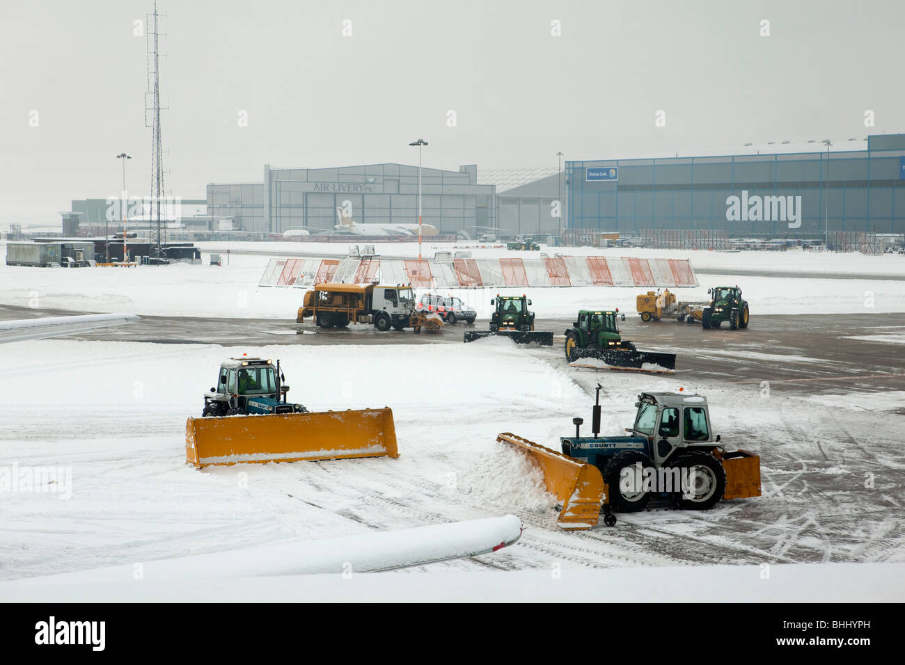 UK, England, Manchester Airport, workers clearing snow and de-icing taxiway Stock Photo