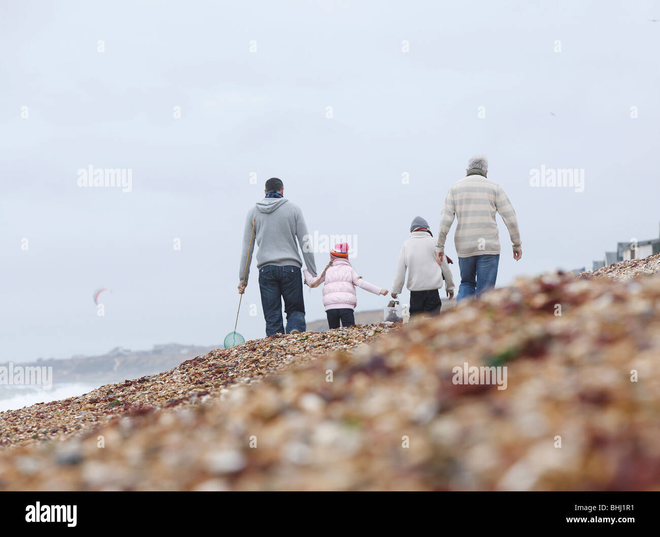 Generations Strolling on Beach Stock Photo