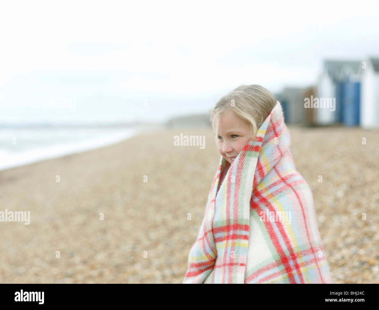 young Girl huddled in blanket Stock Photo