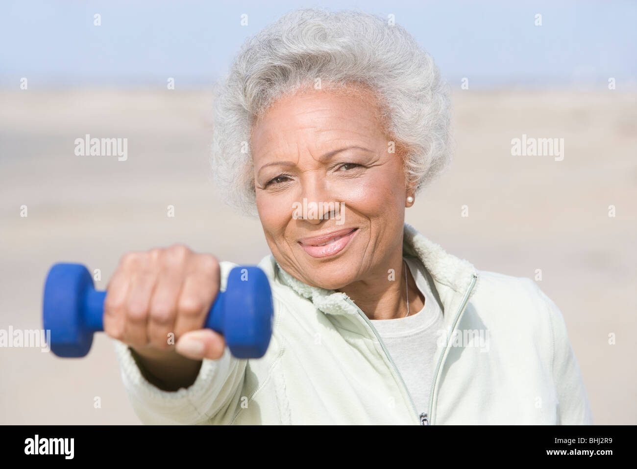 Senior woman excercising with dumbbell on beach Stock Photo - Alamy