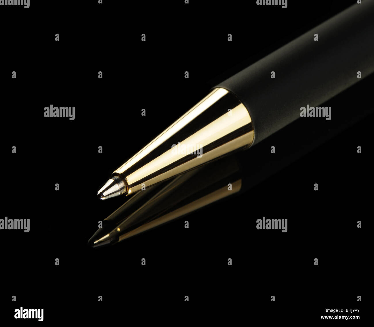 Black pen on a black background. Yellow metal Stock Photo - Alamy