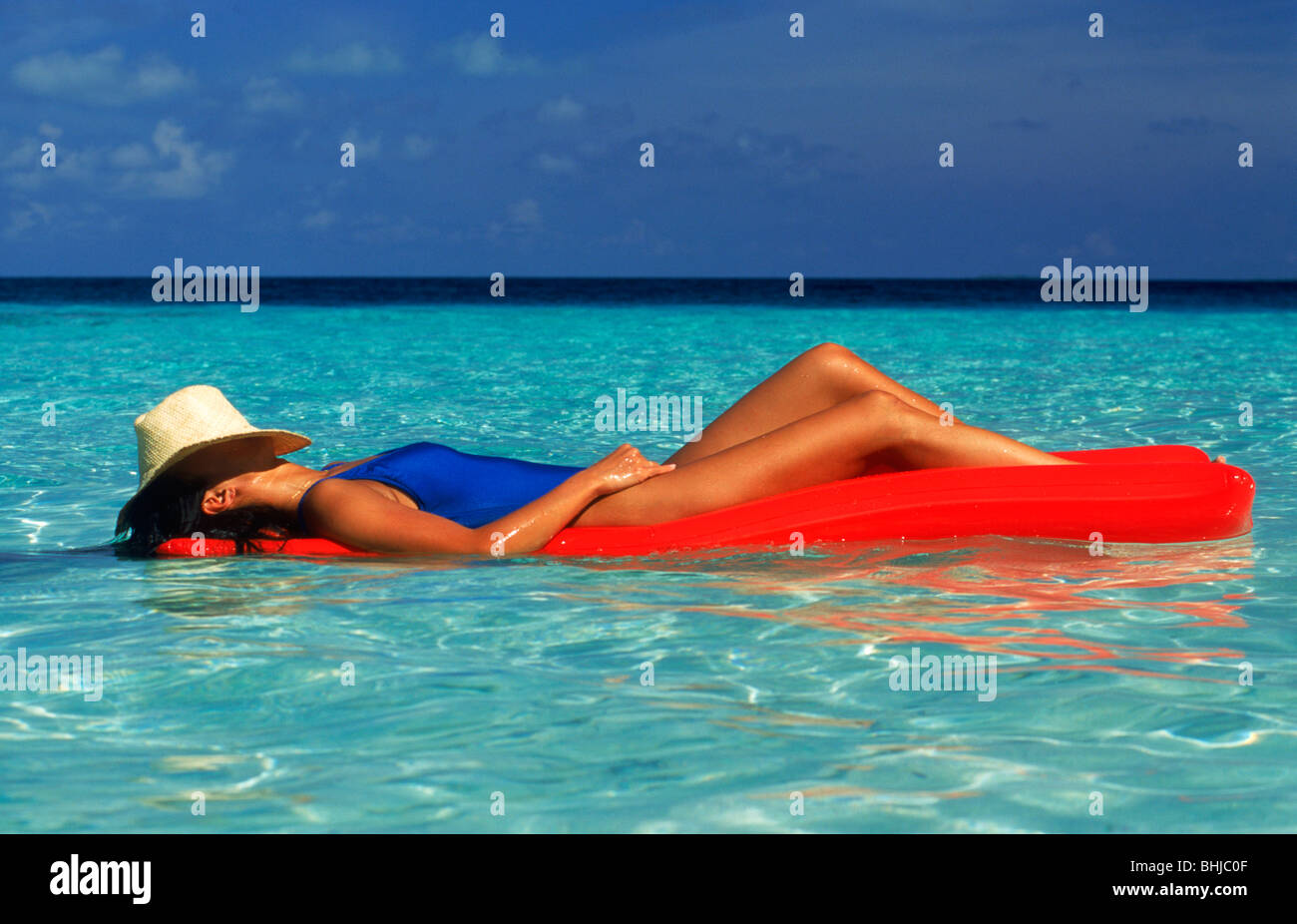 Woman on air mattress in calm waters like floating in paradise Stock Photo  - Alamy