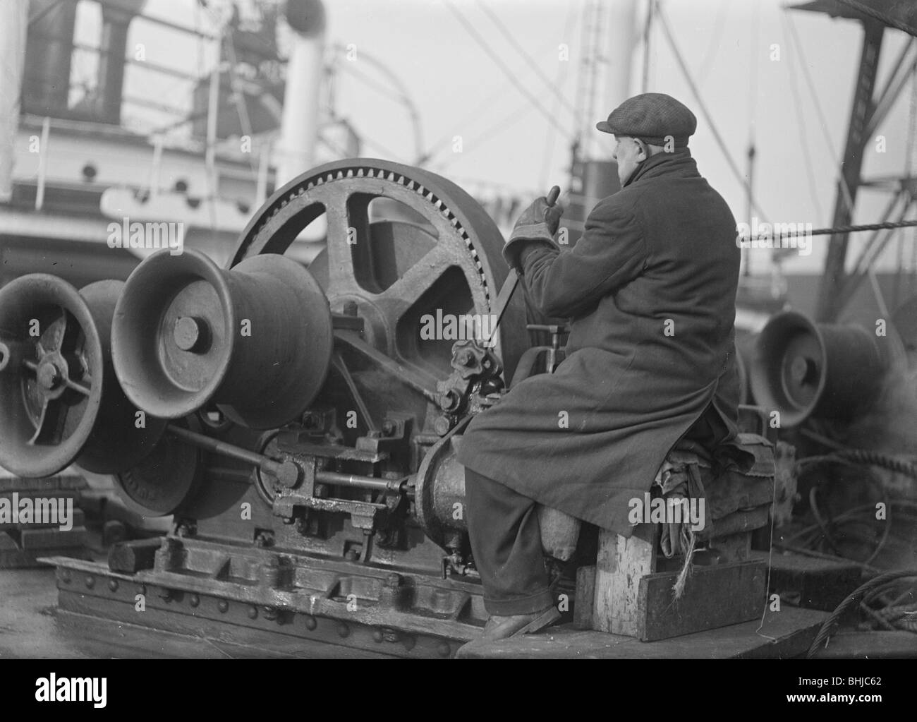 A docker operates a winching gear in London Docks, London, c1945-c1965.  Artist: SW Rawlings Stock Photo