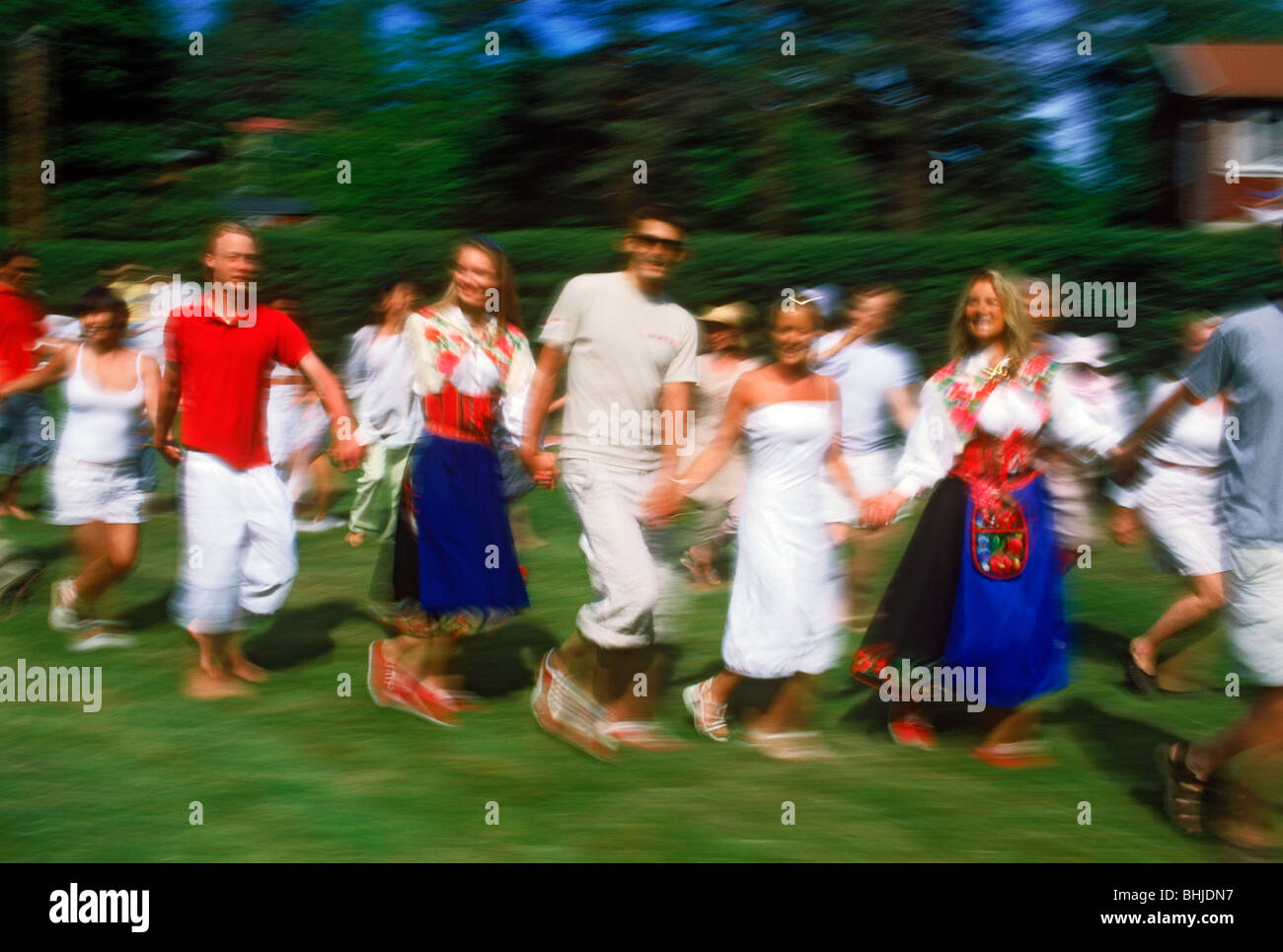 Dancing around Maypole during Midsummer celebrations in Sweden on small island in Stockholm Archipelago Stock Photo