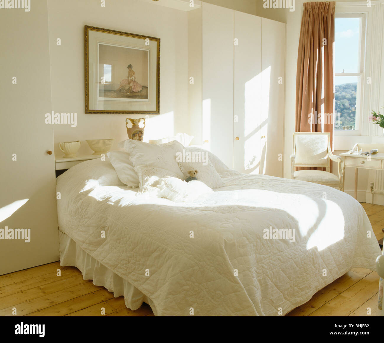 Picture on wall above bed with white quilt in white country bedroom ...