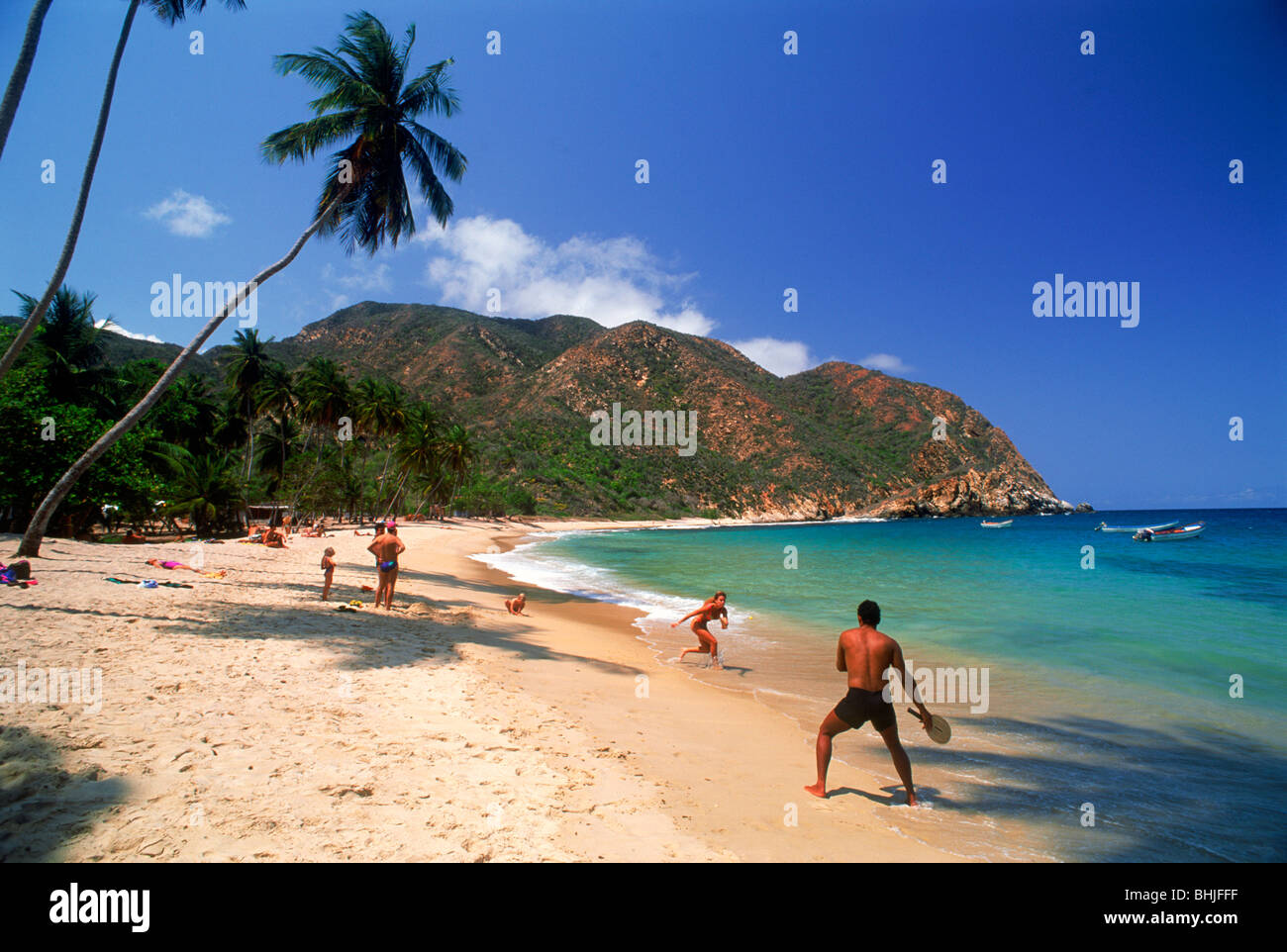 Waves coming to sandy shore with palm trees at  Caribbean village of Choroni approximately three hours West of Caracas Venezuela Stock Photo