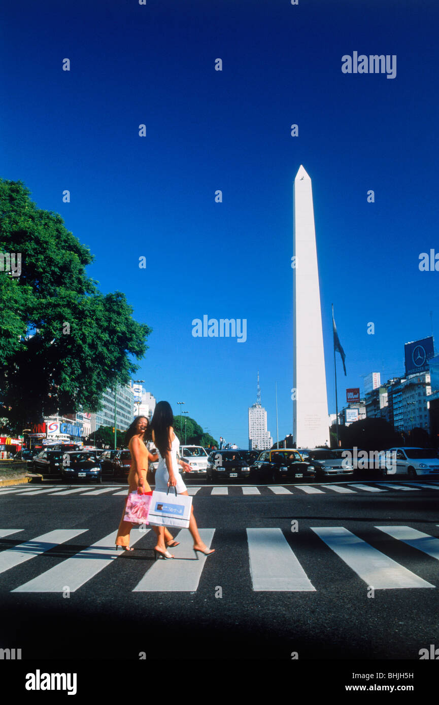 Two women with shopping bags crossing Avenida 9 de Julio near Obelisko in Buenos Aires Stock Photo