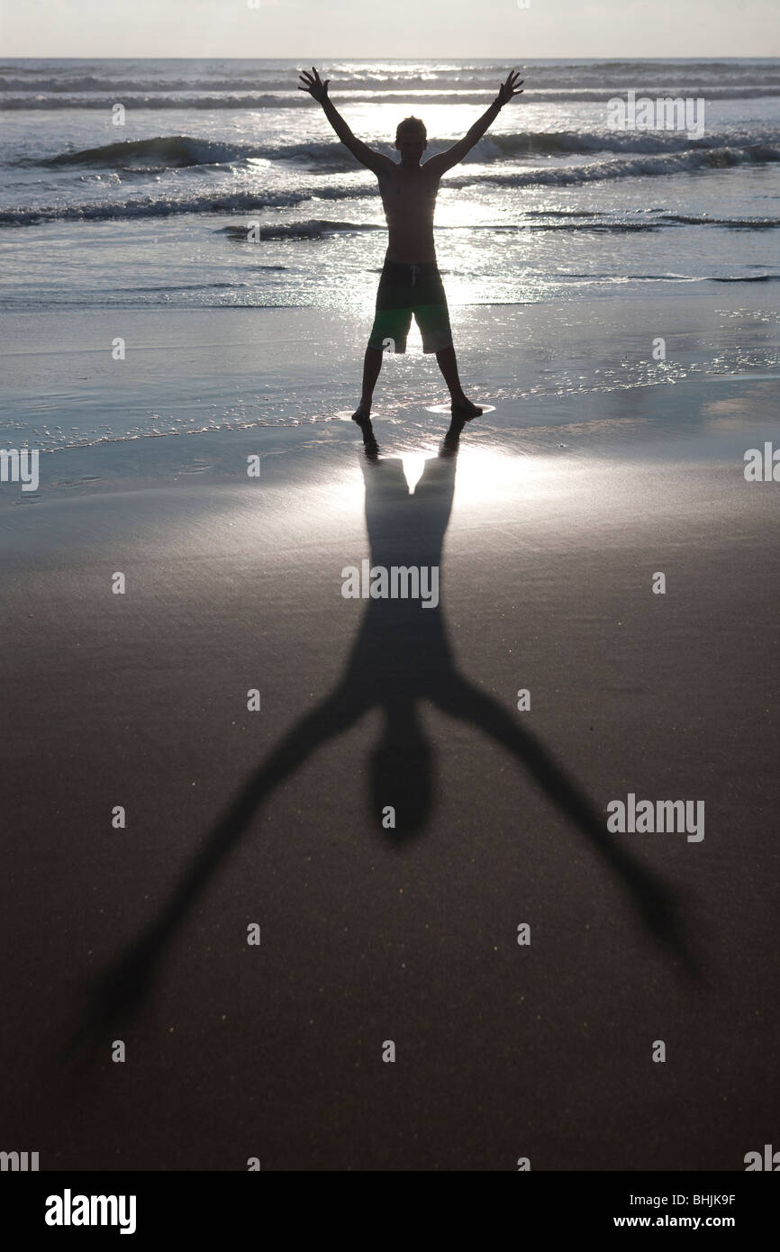 Boy with arms in the air on Mal Pais beach in Costa Rica Stock Photo