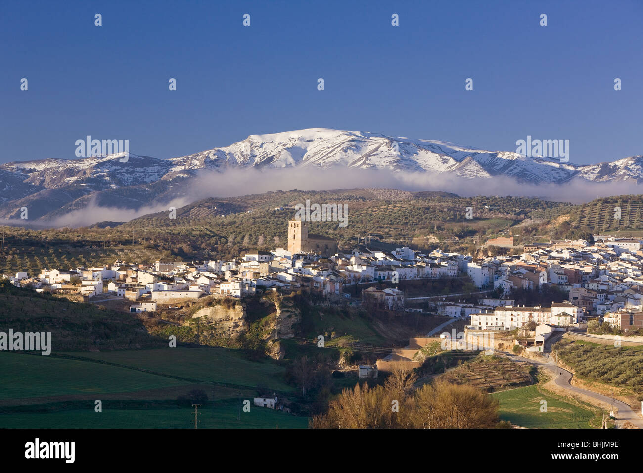 Alhama de Granada with snow covered mountains in distance, Granada, Spain Stock Photo